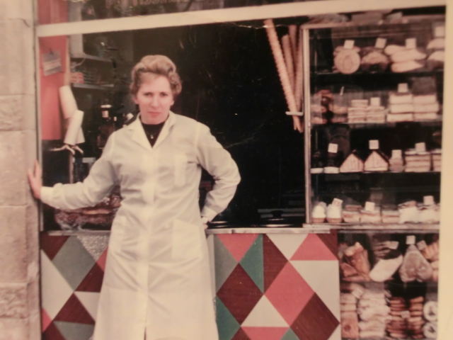 אולגה אסטרייכר בחזית חנות העוגות במחנה יהודה, כנראה שנות ה-50. חלק מהחנות היה גם דוכן למכירת גזוז. ירושלים